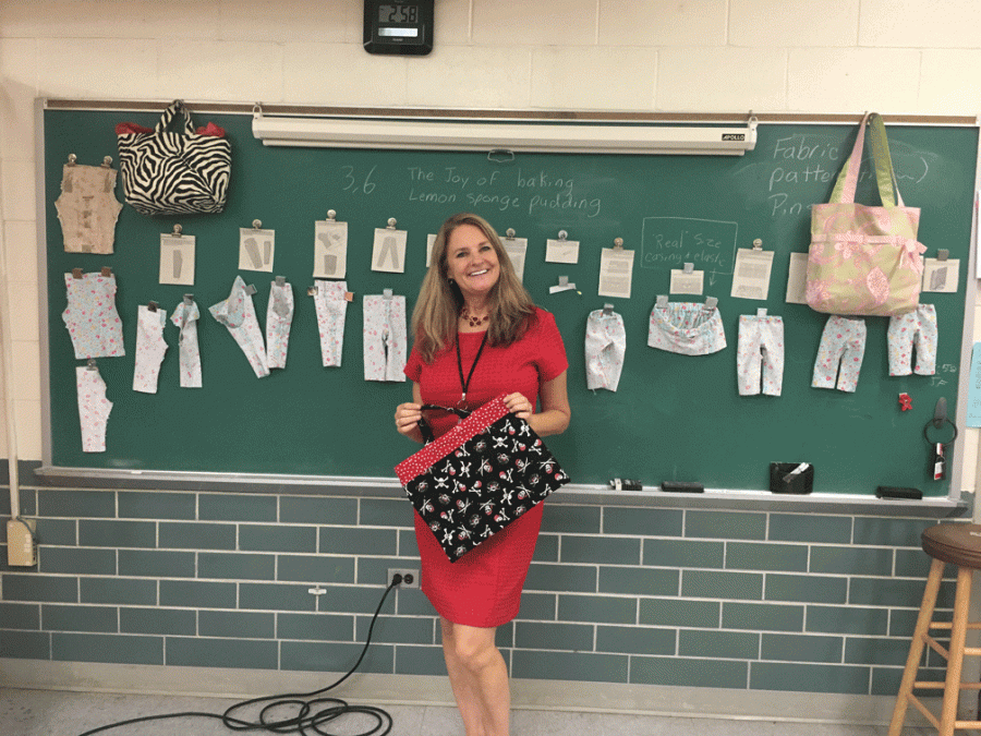 Mrs. Greisinger in her classrom promoting her new fashion class and showing off her fabulous creations. She made the bag she’s holding. It really shows her Pirate spirit! 